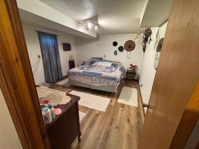 bedroom with hardwood / wood-style flooring and a textured ceiling