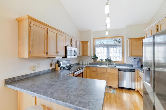 kitchen featuring kitchen peninsula, decorative light fixtures, light brown cabinetry, appliances with stainless steel finishes, and sink