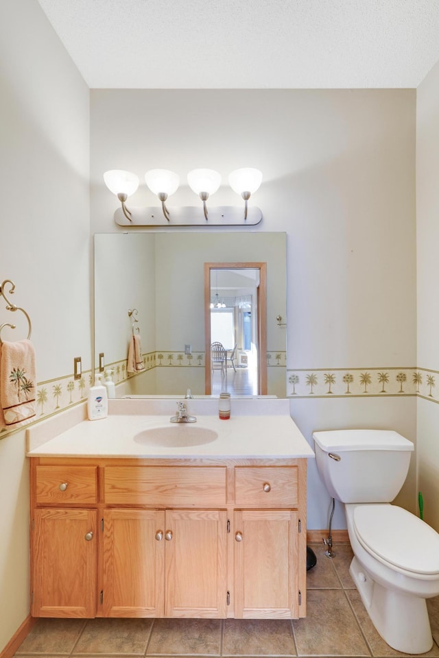 bathroom with toilet, tile patterned flooring, a textured ceiling, and vanity