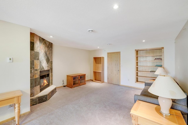 living room with light colored carpet, built in features, and a fireplace