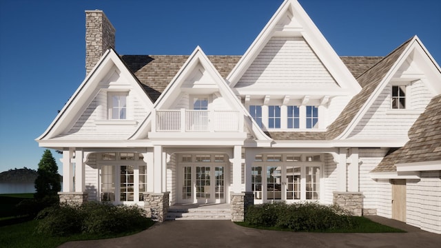 view of front of home with a balcony and french doors