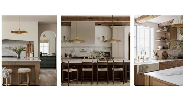 kitchen with light wood-style flooring, light stone counters, a kitchen bar, pendant lighting, and backsplash