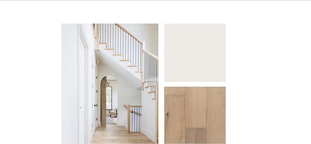 stairs featuring a towering ceiling, arched walkways, and wood finished floors