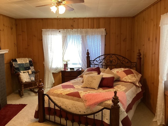 carpeted bedroom with ceiling fan and wooden walls