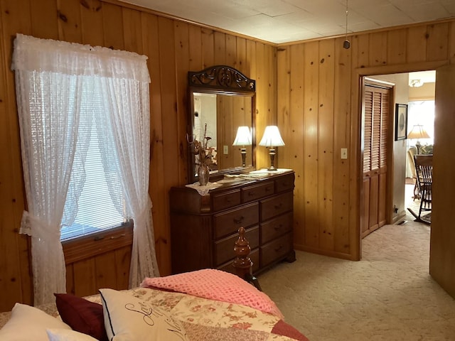 carpeted bedroom featuring wood walls