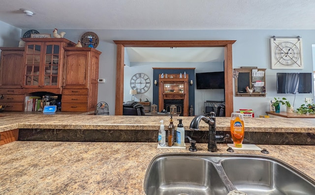 kitchen with sink, a fireplace, and a textured ceiling