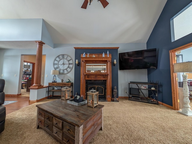 carpeted living room with lofted ceiling, ceiling fan, and ornate columns