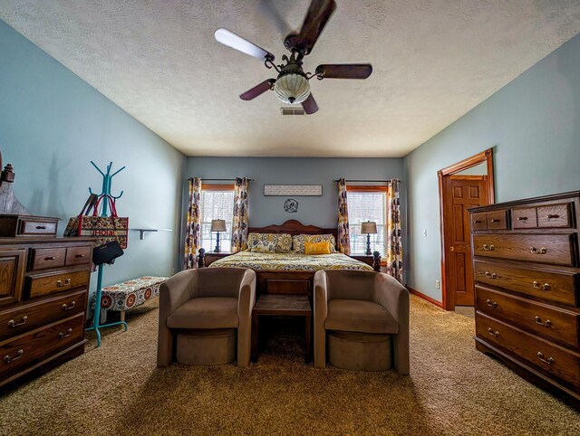 bedroom with multiple windows, ceiling fan, carpet flooring, and a textured ceiling