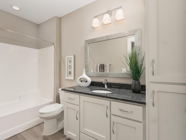 full bathroom with shower / bathtub combination, toilet, vanity, and hardwood / wood-style flooring