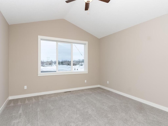 spare room with vaulted ceiling, light carpet, and ceiling fan