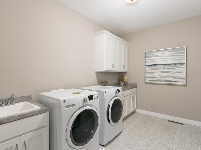 clothes washing area with washer and dryer, cabinets, light tile patterned flooring, and sink