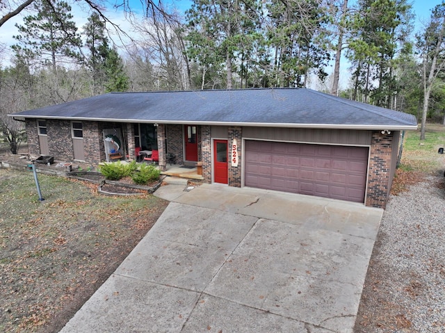 ranch-style home with covered porch, driveway, a garage, brick siding, and a shingled roof