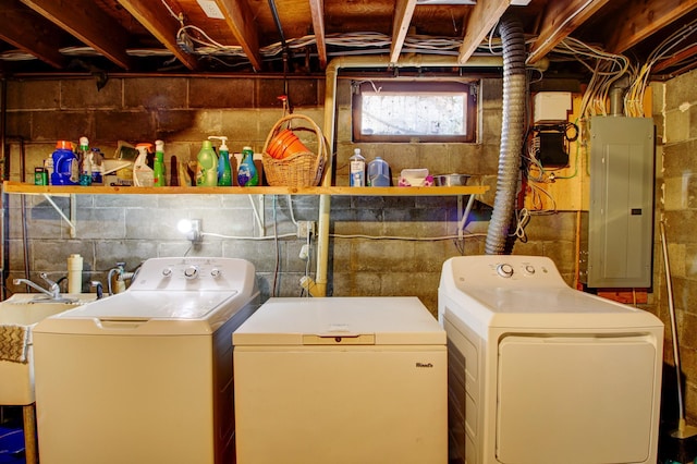 washroom featuring electric panel, laundry area, a sink, and washing machine and clothes dryer