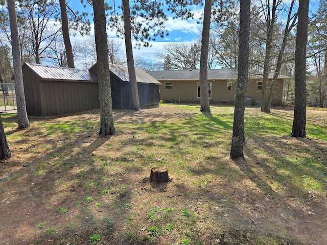 view of yard with fence and an outdoor structure