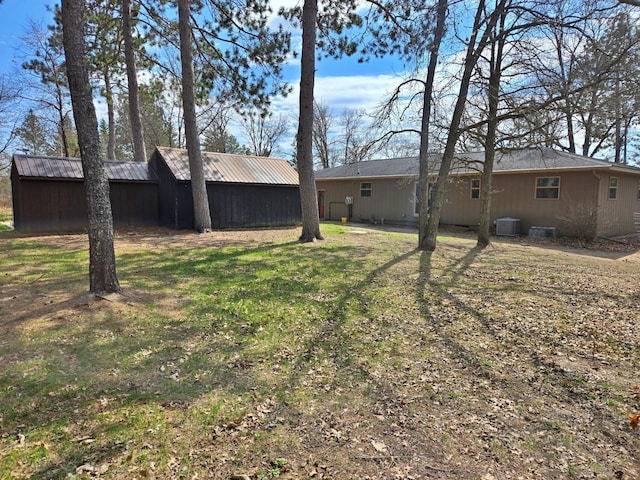 view of yard with central AC and an outbuilding