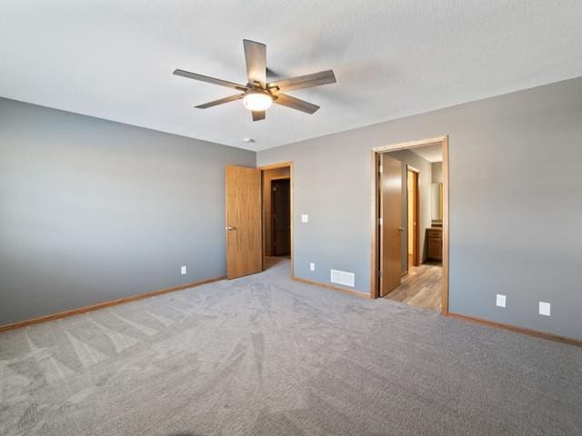 unfurnished bedroom with ceiling fan and light colored carpet