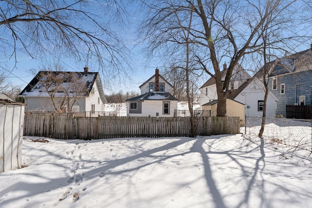 yard layered in snow with a fenced front yard