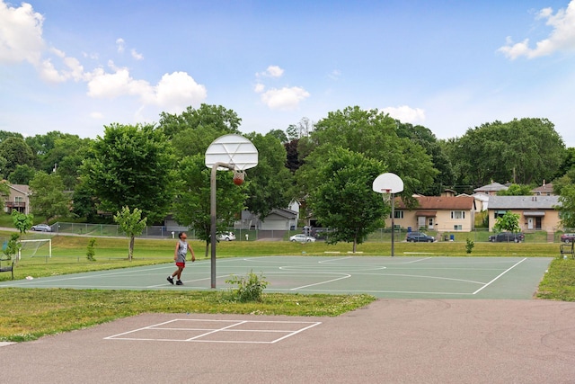 view of basketball court with community basketball court, a lawn, and fence