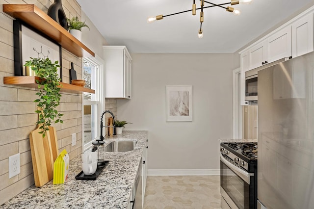 kitchen with white cabinetry, stainless steel appliances, sink, backsplash, and light stone counters