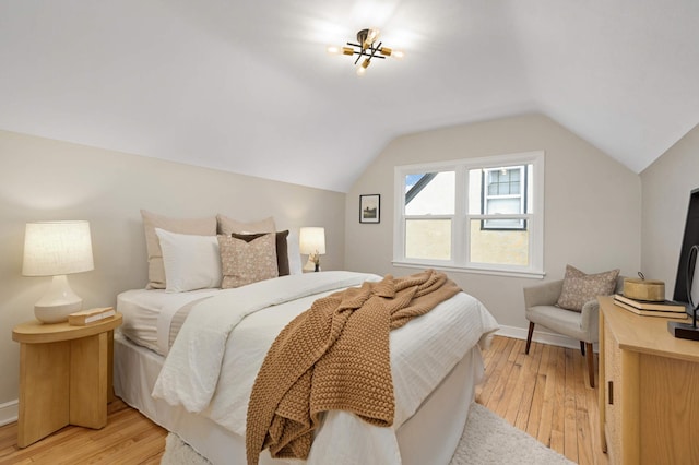 bedroom featuring lofted ceiling and light hardwood / wood-style flooring