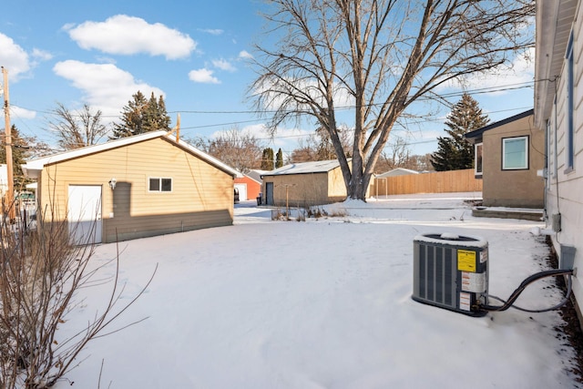 snowy yard with an outbuilding and central AC