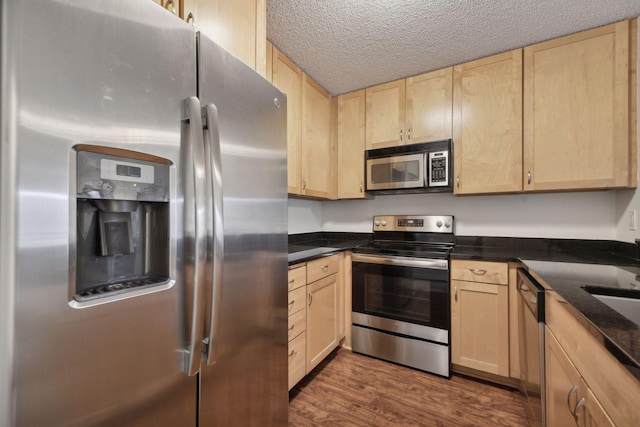 kitchen with dark hardwood / wood-style flooring, light brown cabinets, and appliances with stainless steel finishes