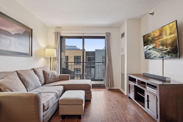 living room featuring dark hardwood / wood-style floors and a textured ceiling