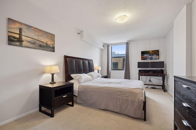 bedroom featuring light colored carpet and a textured ceiling