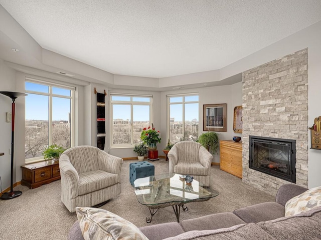 carpeted living room featuring a stone fireplace and a textured ceiling