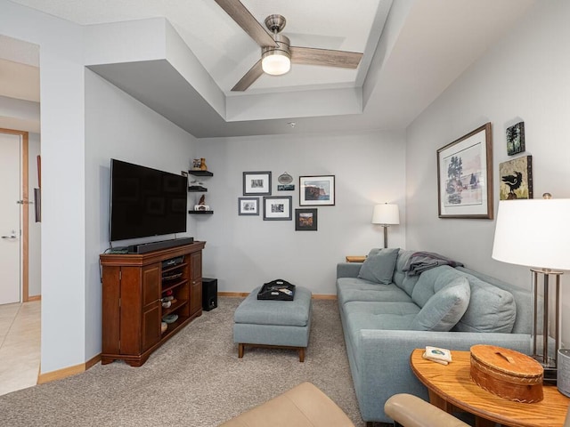 carpeted living room featuring ceiling fan and a raised ceiling