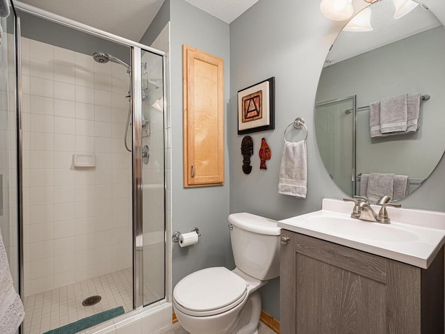 bathroom with vanity, a shower with shower door, and toilet