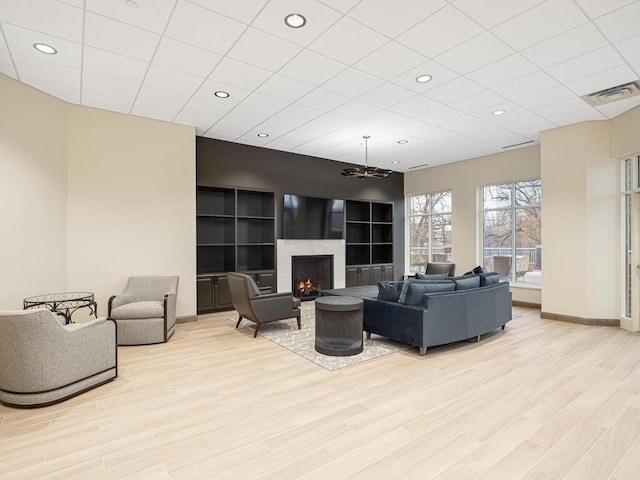 living room featuring light wood-type flooring and a high end fireplace