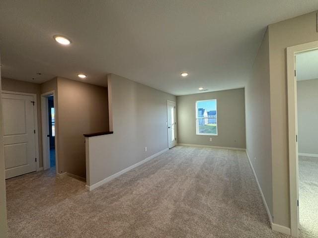 unfurnished room featuring light colored carpet