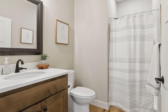 bathroom with hardwood / wood-style flooring, toilet, and vanity