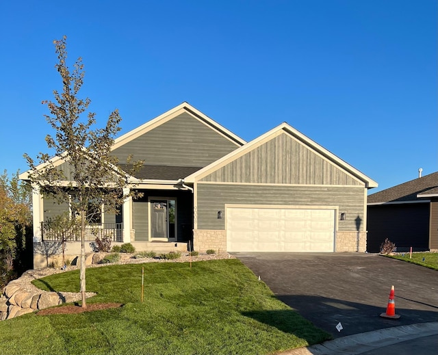 craftsman inspired home with a garage, a front lawn, and covered porch