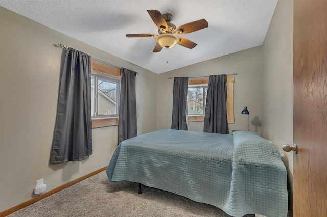 carpeted bedroom featuring lofted ceiling, multiple windows, a textured ceiling, and ceiling fan