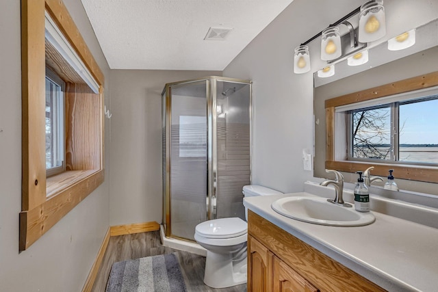 bathroom featuring lofted ceiling, a shower with shower door, hardwood / wood-style flooring, toilet, and vanity