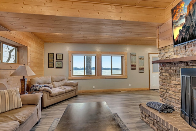 living room with wooden walls, a fireplace, lofted ceiling, light hardwood / wood-style flooring, and wood ceiling