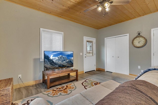 living room featuring light hardwood / wood-style floors, ceiling fan, and wooden ceiling