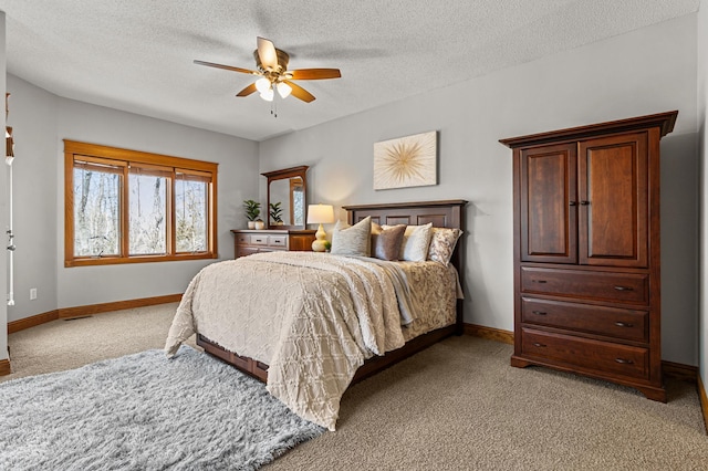 bedroom featuring light colored carpet, baseboards, and a textured ceiling