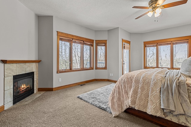 bedroom featuring visible vents, a fireplace, baseboards, and carpet floors