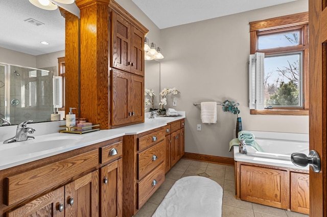 bathroom featuring tile patterned flooring, baseboards, double vanity, a stall shower, and a sink