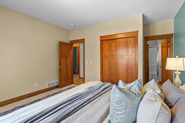 bedroom featuring visible vents, baseboards, a textured ceiling, and a closet