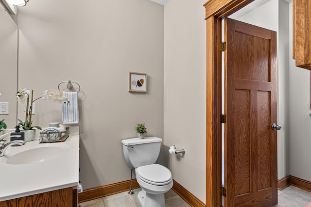 bathroom featuring tile patterned flooring, toilet, vanity, and baseboards