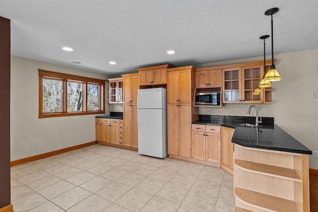 kitchen with open shelves, stainless steel microwave, a sink, freestanding refrigerator, and a peninsula