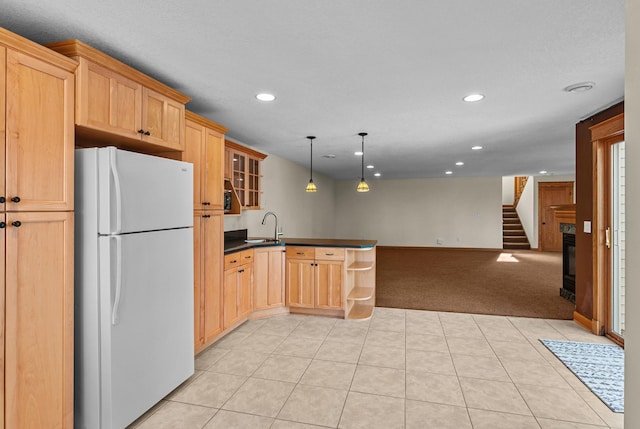 kitchen with dark countertops, open floor plan, recessed lighting, a peninsula, and freestanding refrigerator