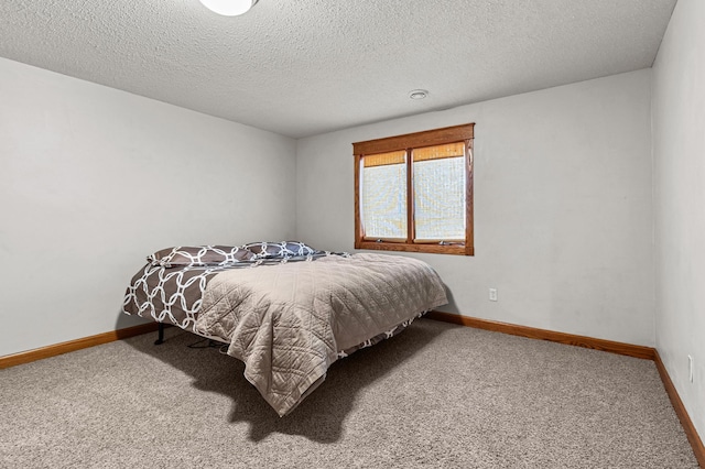 bedroom with baseboards, a textured ceiling, and carpet flooring