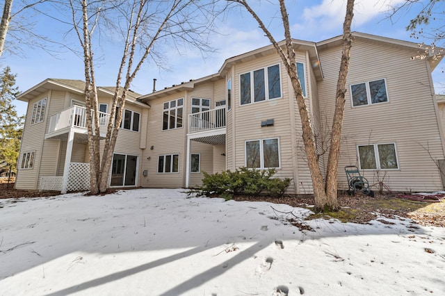 snow covered property with a balcony