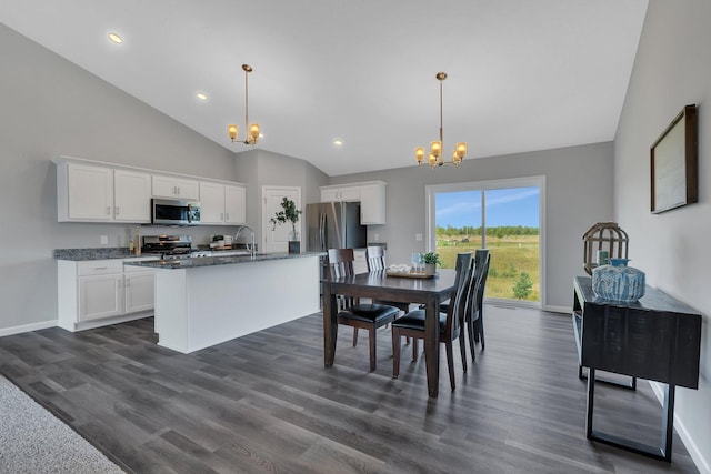 dining room featuring sink, a high ceiling, dark hardwood / wood-style flooring, and an inviting chandelier