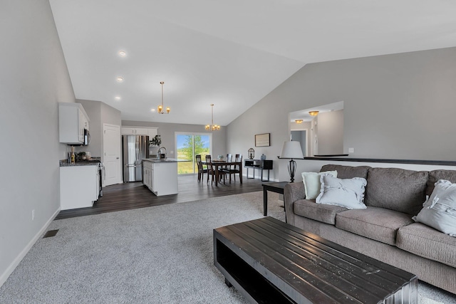 living room with dark colored carpet, vaulted ceiling, a chandelier, and sink